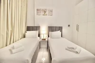 two beds sitting next to each other in a room at 2BR Duplex Stunning Views,Near Circle Mall & Park in Dubai