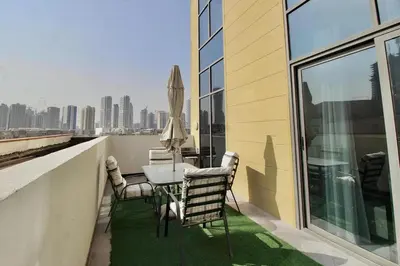 a patio with a table and chairs on a balcony at 2BR Duplex Stunning Views,Near Circle Mall & Park in Dubai
