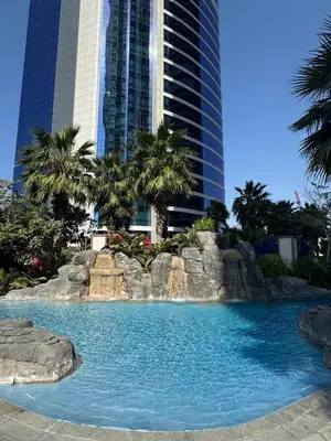 a swimming pool with a waterfall in front of a building at Mahogany 1 - 2BR 6 PAX - Amazing Oasis - 1500 sqft in Dubai