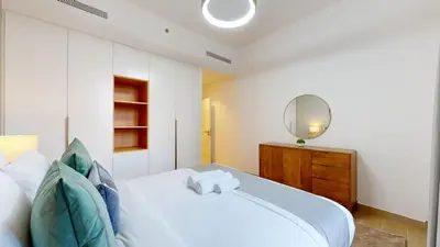 a bedroom with a white bed and a mirror at La Sirene 3 - Elegant Two Bedroom in Jumeirah 1 in Dubai