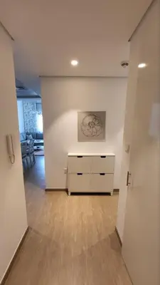 a living room with a dresser and a painting on the wall at Modern 2BR -5min to Metro-Unit 211 in Dubai