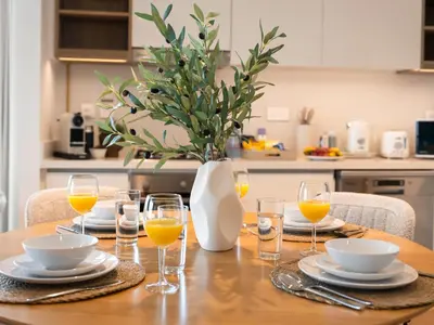 a table with glasses and a vase with orange juice at The Cinema Suite Luxury 2-Bed Near Dubai Mall in Dubai