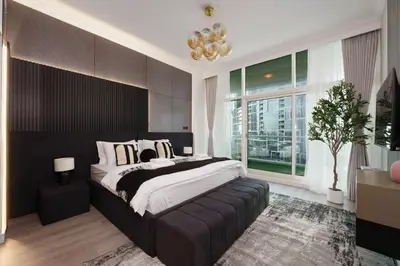 a bedroom with a large bed and a large window at Opulent Flat with Beach, Pool & Canal View in JBR in Dubai