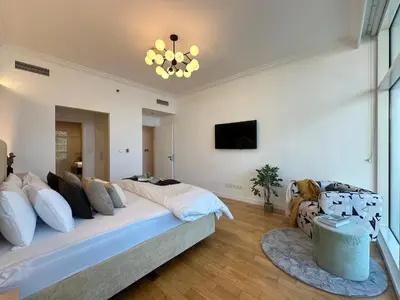 a bedroom with a large bed and a tv at Opulent Flat with Beach, Pool & Canal View in JBR in Dubai