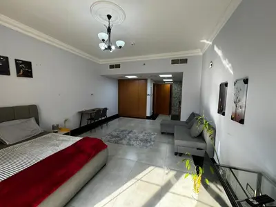 a bedroom with a bed and a living room at Specious Fully furnished studio in May residence in Dubai