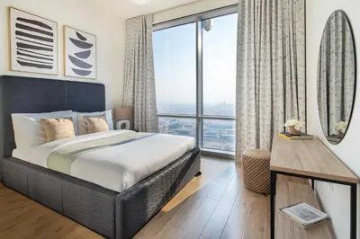 a bedroom with a bed and a large window at Frank Porter - Amna Tower in Dubai