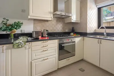 a kitchen with white cabinets and a stove top oven at Frank Porter - Tajer Tower E in Dubai