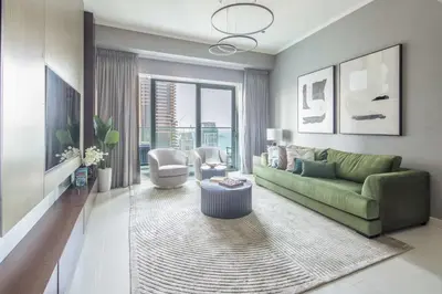 a living room with a green couch and a table at Frank Porter - Damac Heights in Dubai