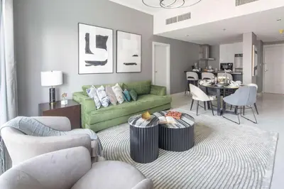 a living room with a green couch and a table at Frank Porter - Damac Heights in Dubai