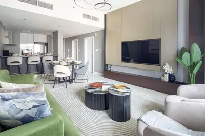 a living room with a couch and a tv at Frank Porter - Damac Heights in Dubai
