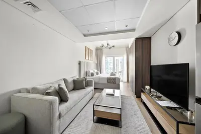 a living room with a couch and a flat screen tv at Stunning Lake View Apartment in JLT in Dubai