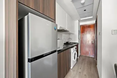 a kitchen with a refrigerator and a washer and dryer at Stunning Lake View Apartment in JLT in Dubai