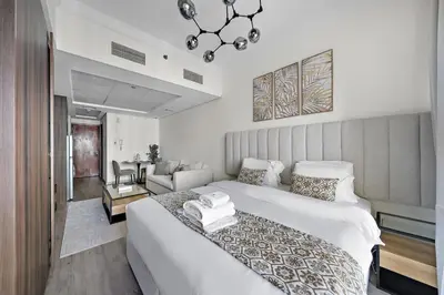 a bedroom with a large bed and a living room at Stunning Lake View Apartment in JLT in Dubai