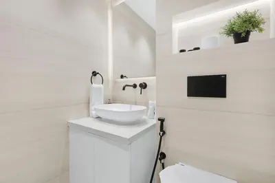 a white bathroom with a sink and a mirror at Luxury 2BR Apartment Near JBR Beach with Pool and Gym Access in Dubai