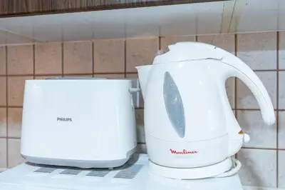 a white appliance sitting on a counter next to a toaster at 1BHK in central of Dubai Marina in Dubai