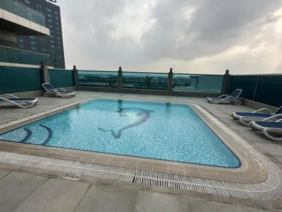 a woman swimming in a swimming pool on top of a building at Elite Residence business bay Downtown Dubai in Dubai