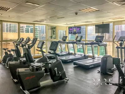 a gym with rows of treadmills and cardio machines at Rare Holiday Homes - Marina Quays West Tower - Near the Beach - R1003 - Dubai Marina in Dubai