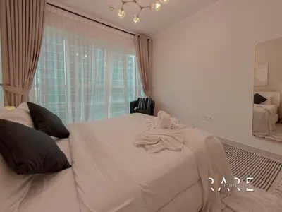 a bedroom with a white bed with a towel on it at Rare Holiday Homes - Marina Quays West Tower - Near the Beach - R1003 - Dubai Marina in Dubai