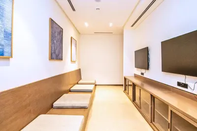 a waiting room with three benches and a flat screen tv at GRANDE SIGNATURE- 2BR Apartment with full Burj Khalifa views in Dubai