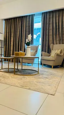 a living room with two chairs and a coffee table at MontRose residence Tower A 1BR Apartment in Dubai