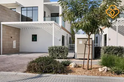 a white building with a tree in front of it at Keysplease 4BR, Nanny room, BBQ, Garden, Malibu Beach Access, Damac Hills in Dubai