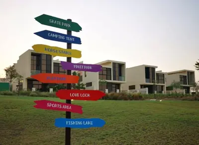 a directional sign in front of a building at Keysplease 4BR, Nanny room, BBQ, Garden, Malibu Beach Access, Damac Hills in Dubai