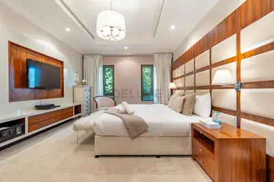 a bedroom with a large bed and a flat screen tv at Exclusive Beachfront Villa with Private Beach Access, Next to the Community Pool, Close to Aquaventure Waterpark, Monorail, and Nakheel Mall, Canal Cove, Palm Jumeirah by Deluxe Holiday Homes in Dubai