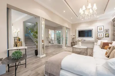 a bedroom with a white bed and a living room at Exclusive Beachfront Villa with Private Beach Access, Next to the Community Pool, Close to Aquaventure Waterpark, Monorail, and Nakheel Mall, Canal Cove, Palm Jumeirah by Deluxe Holiday Homes in Dubai
