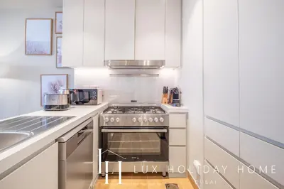 a kitchen with white cabinets and a stove top oven at LUX The La Mer Infinity View - Luxury Boho Suite 1 in Dubai