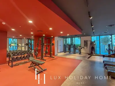 a gym with treadmills and weights in a room at LUX The La Mer Infinity View - Luxury Boho Suite 1 in Dubai