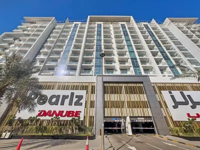 a large white building with a sign in front of it at Stylish Studio Close To Metro at Pearlz by Danube in Dubai