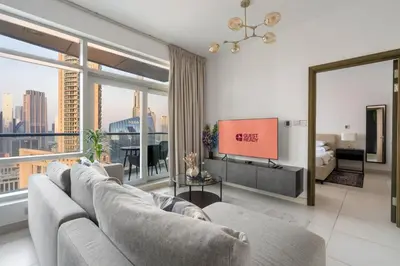 a living room with a couch and a tv at GuestReady - Downtown charm with skyline views in Dubai