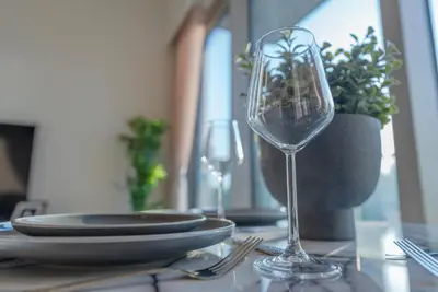 a table with two wine glasses and plates on it at Downtown Luxury - Elegant 1-Bedroom Apartment - 5 Minutes Walk to Dubai Mall in Dubai