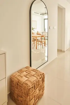 a wicker ottoman in a living room with a mirror at Paramount - Luxury 2BR Apartments with Burj and Sea Views - Access to the Infinity Pool on 64th Floor in Dubai