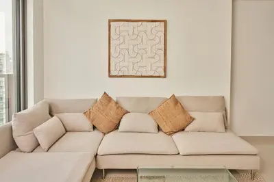 a living room with a couch with pillows at Paramount - Luxury 2BR Apartments with Burj and Sea Views - Access to the Infinity Pool on 64th Floor in Dubai
