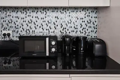 a microwave sitting on top of a kitchen counter at Paramount - Luxury 2BR Apartments with Burj and Sea Views - Access to the Infinity Pool on 64th Floor in Dubai