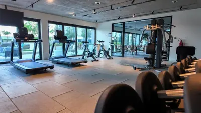 a gym with several treadmills and elliptical machines at One bedroom apartment brand new Dubai Hills ultra luxury furniture in Dubai