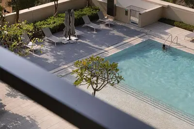 an overhead view of a swimming pool with chairs and umbrellas at Full Burj Khalifa View! Brand New 2 Bedrooms! 5min walk From Dubai Mall! in Dubai