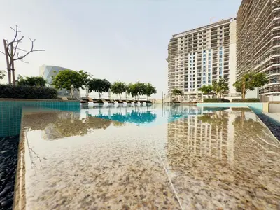 a swimming pool with a reflection of a building at Luxe Escape at Dubai Hills in Dubai