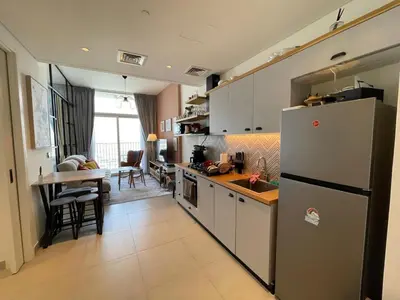a kitchen with a refrigerator and a table in it at Luxe Escape at Dubai Hills in Dubai