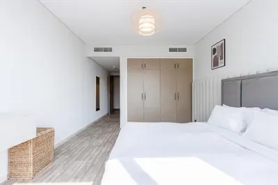 a white bedroom with a large bed and a closet at Livbnb-2B Stunner with Iconic Ain Dubai View in Dubai