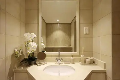 a bathroom with a sink and a mirror and flowers at Livbnb-2B Stunner with Iconic Ain Dubai View in Dubai