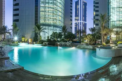 a large pool in a city with tall buildings at Livbnb-2B Stunner with Iconic Ain Dubai View in Dubai