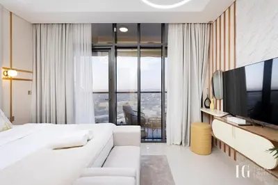 a hotel room with a white bed and a television at Sky-High Aykon City Studio in Dubai