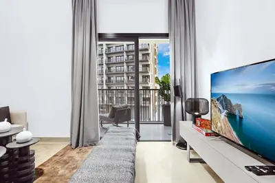 a living room with a couch and a large screen tv at Luxury 1BR City View with Balcony Parking & WiFi Near Dining & Downtown in Dubai