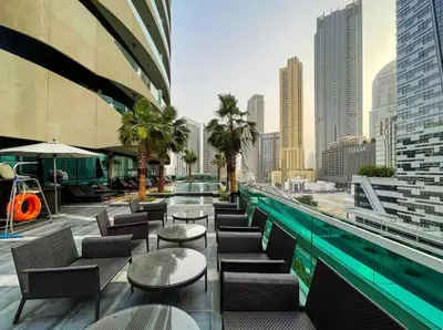 a rooftop pool with tables and chairs and a city at Downtown 1BR - 5 minutes to mall - panoramic pool in Dubai
