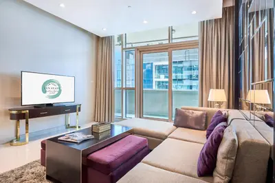 a living room with a couch and a tv at Downtown 1BR - 5 minutes to mall - panoramic pool in Dubai