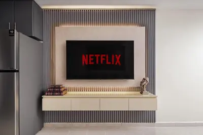 a television on a wall with a netflix sign at Modern Studio Apartment in Lake View in Dubai
