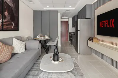 a living room with a couch and a kitchen at Modern Studio Apartment in Lake View in Dubai