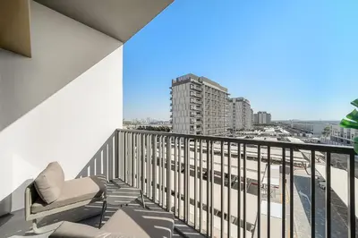 a balcony with chairs and a view of a city at Bright Studio in MAG Eye in Dubai